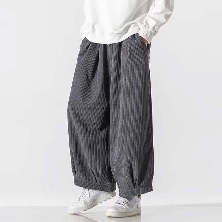 Oversized Vera corduroy pants with deep pleats and relaxed silhouette, styled with a white sweatshirt and sneakers.
