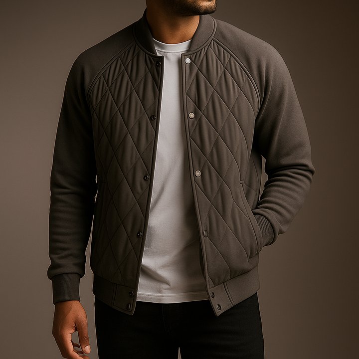 Man wearing a quilted jacket over a white shirt on a brown background