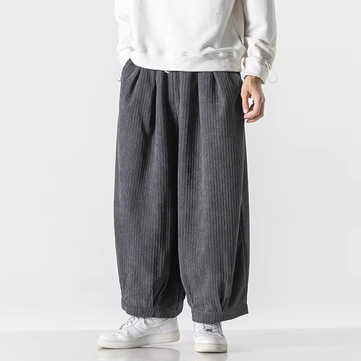 Men's oversized corduroy pants featuring deep pleats and an elastic waistband for comfortable, effortless style.