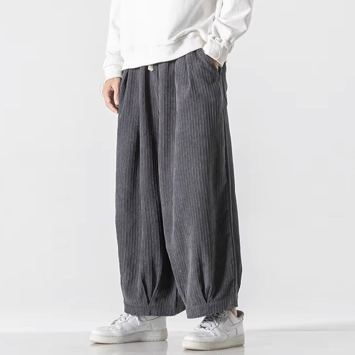 Vera Corduroy Pants showcasing a wide-leg, relaxed silhouette with deep pleats and elastic waistband for effortless comfort.