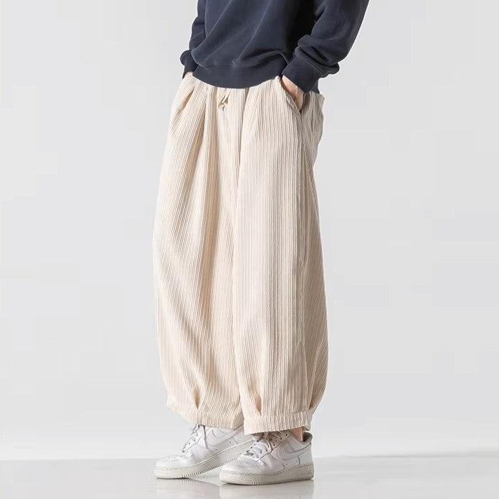 Vera Corduroy Pants featuring deep pleats, wide-leg silhouette, and an elastic waistband for comfort.