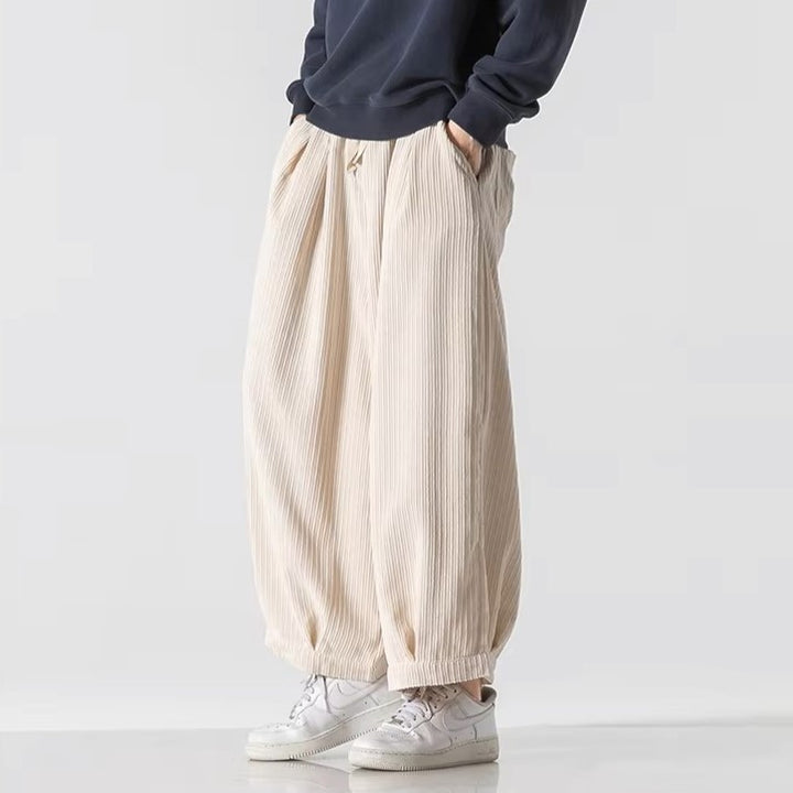 Vera Corduroy Pants featuring deep pleats, wide-leg silhouette, and an elastic waistband for comfort.