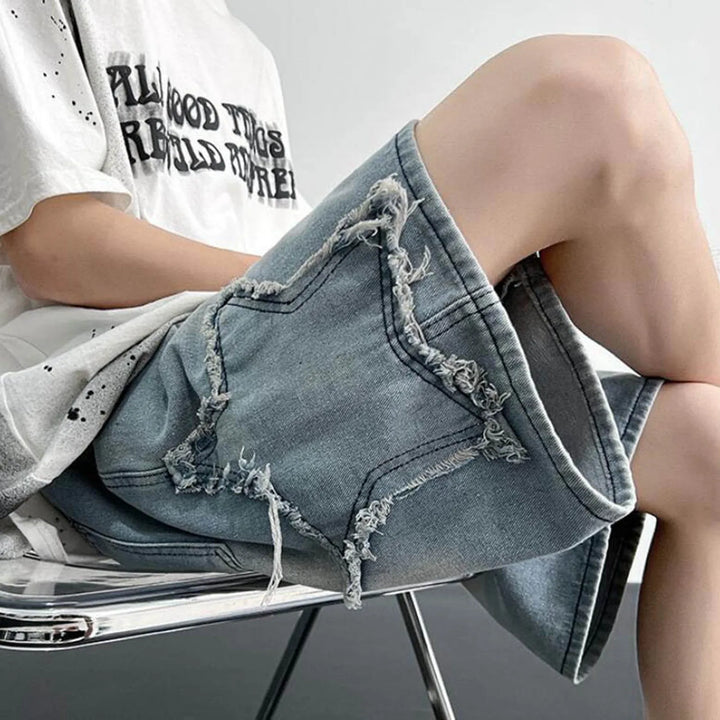Casual model wearing Sidestar washed denim shorts with frayed star patches and a relaxed skater fit.