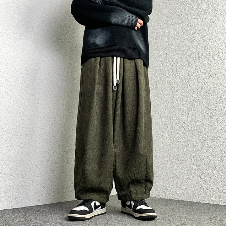 Model wearing Arlo Corduroy Pants with wide-leg fit and adjustable drawstring waist, styled for a relaxed streetwear look.