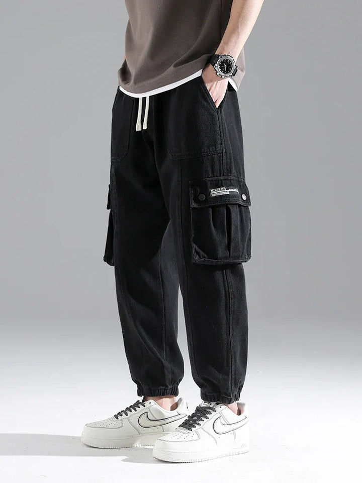 Lennox Cargo Joggers in black with deep cargo pockets, elastic cuffs, and relaxed fit for a stylish everyday look.