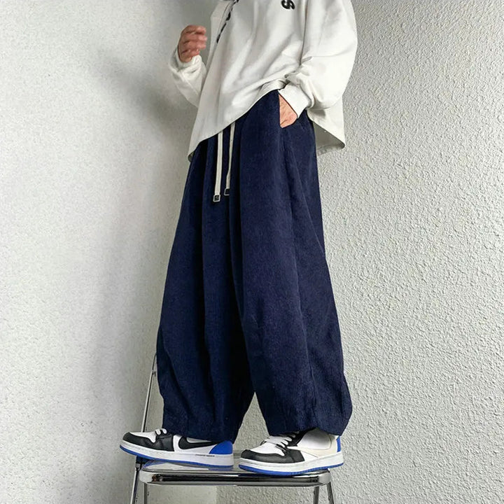 Model wearing Arlo corduroy pants with wide-leg fit, styled with a casual hoodie and sneakers.