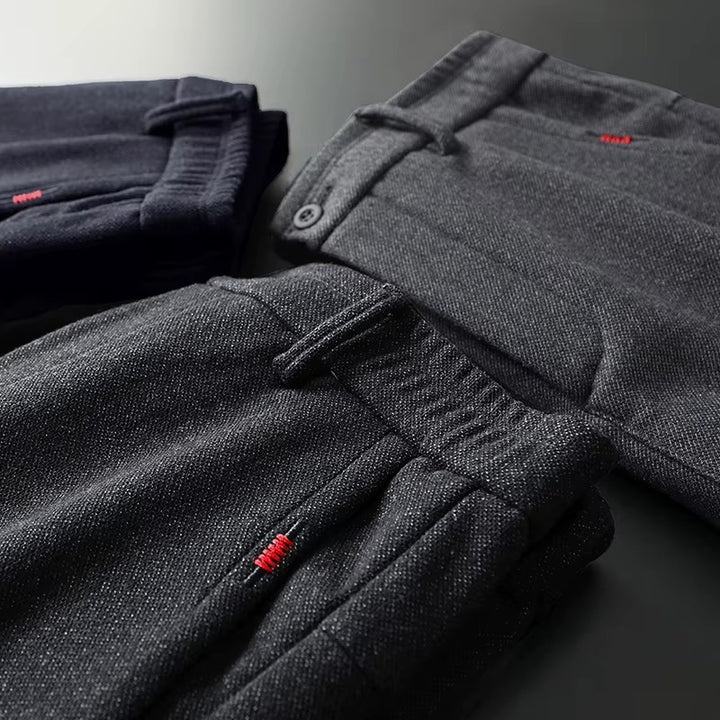 Henderson Slim-Fit Pants in dark colors folded, showcasing modern design and soft cotton-bamboo blend fabric.