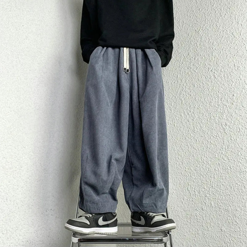Relaxed-fit Arlo corduroy pants in gray with adjustable drawstring waist and deep pockets, styled with sneakers.