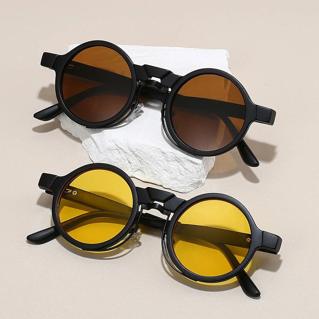 Astor Vintage Shades: two pairs of round sunglasses with brown and yellow lenses on a stone surface.