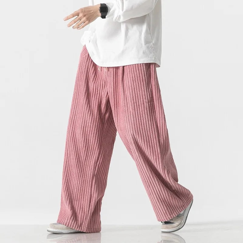 Oversized pink corduroy pants with wide-leg fit and elastic waistband, showcasing a relaxed style.