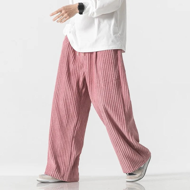 Oversized pink corduroy pants with wide-leg fit and elastic waistband, showcasing a relaxed style.