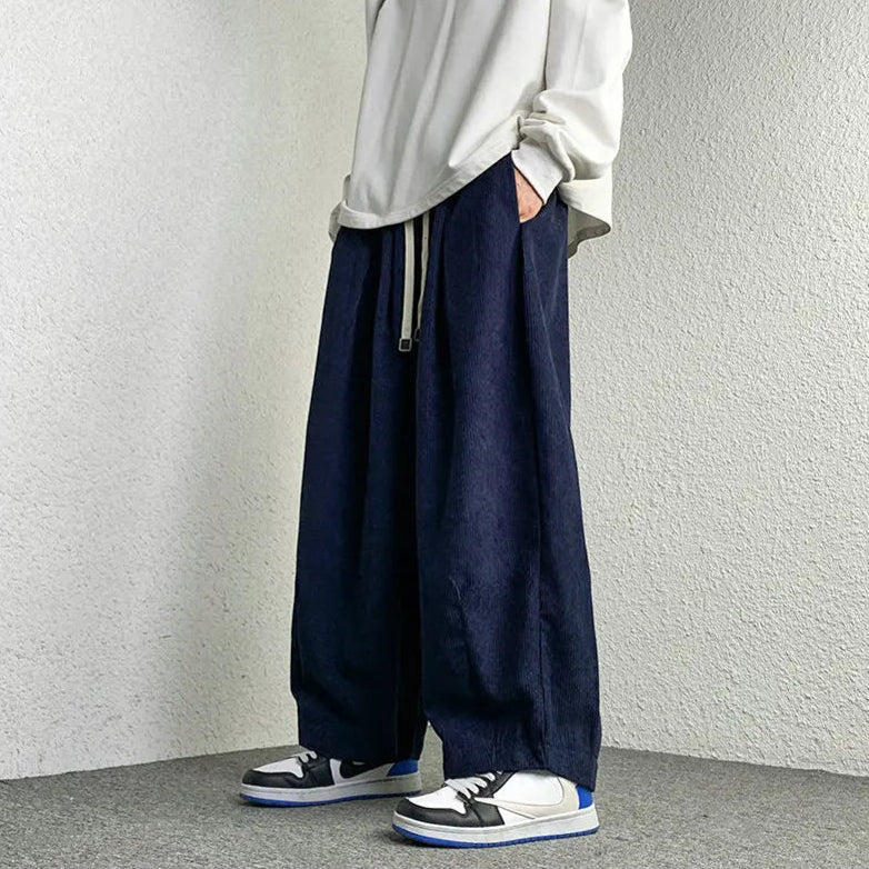 Arlo Corduroy Pants in navy, featuring a wide-leg fit, adjustable drawstring waist, and stylish sneakers.