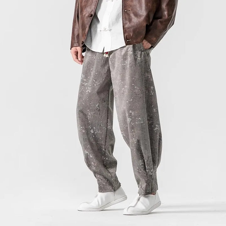 Men's crushed velvet joggers in relaxed fit, featuring elastic cuffs and a stylish gray sheen.