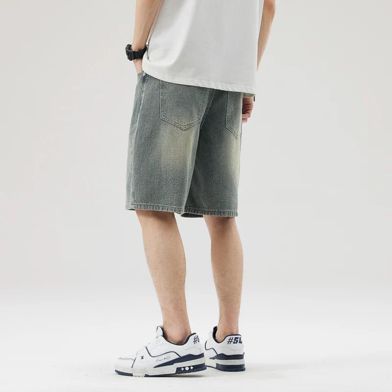 Back view of men’s Axel Faded Wash Denim Shorts with unique crosshatch pattern and tonal fade, styled with sneakers.