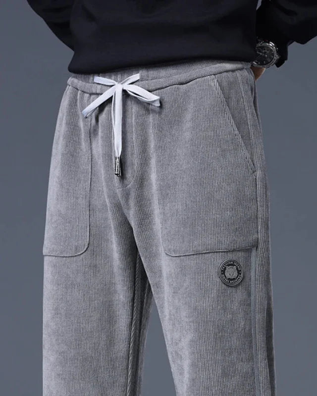 Amos corduroy joggers in gray with adjustable drawstring waist and large front pockets, relaxed tapered fit.