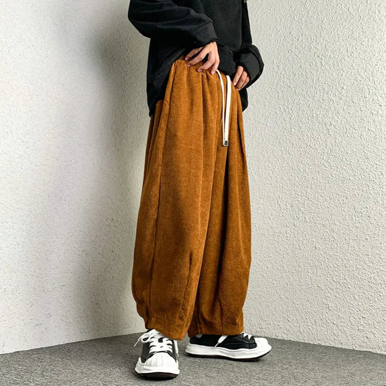 Model wearing Arlo corduroy pants featuring a relaxed wide-leg fit and adjustable drawstring waist in a stylish outfit.