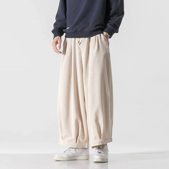 Vera corduroy pants featuring a relaxed silhouette, deep pleats, and an elastic waistband for comfort and style.
