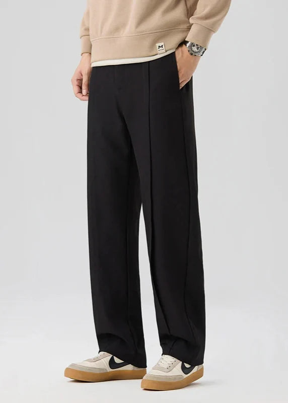 Calloway pleated trousers in black, featuring a relaxed straight-leg design and elegant pleated front for comfort and style.