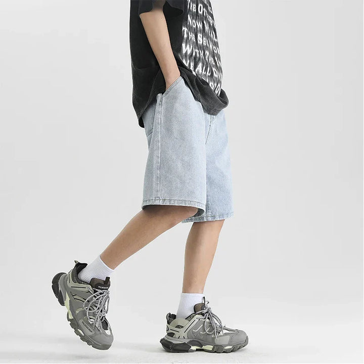 Lennox Men's relaxed fit denim shorts in light wash, paired with oversized shirt and sneakers for a casual look.