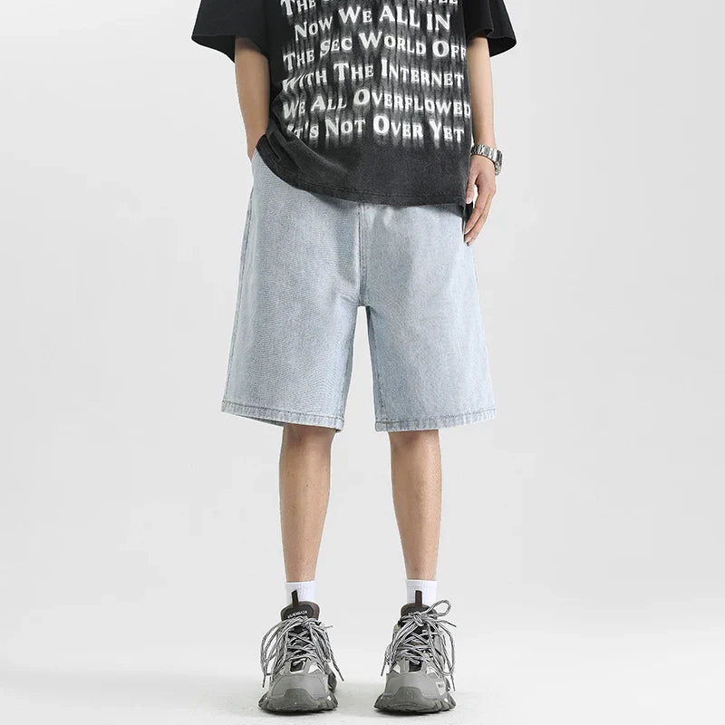Men's relaxed denim shorts in light blue, styled with a graphic tee and sneakers for a casual, skater-inspired look.