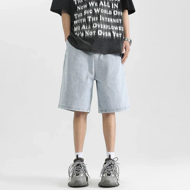 Men's relaxed denim shorts in light blue, styled with a graphic tee and sneakers for a casual, skater-inspired look.