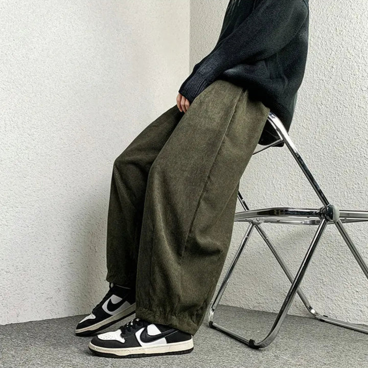 Model wearing Arlo corduroy pants in olive, featuring wide-leg fit and relaxed style, paired with sneakers.