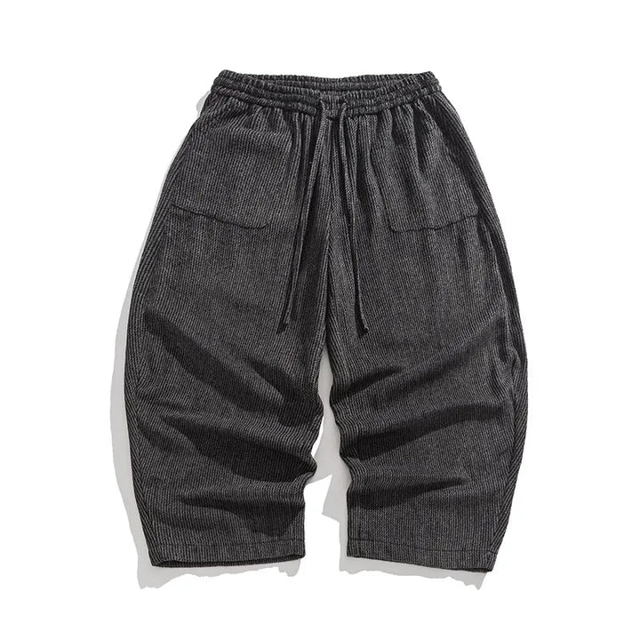 Henderson wide-leg corduroy pants in dark gray with gathered elastic waistband and deep pleats for a relaxed fit.