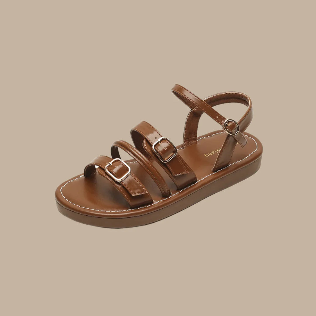 Luna Leather Flat Sandals featuring soft brown leather straps and triple buckle closures for a secure fit and all-day comfort.
