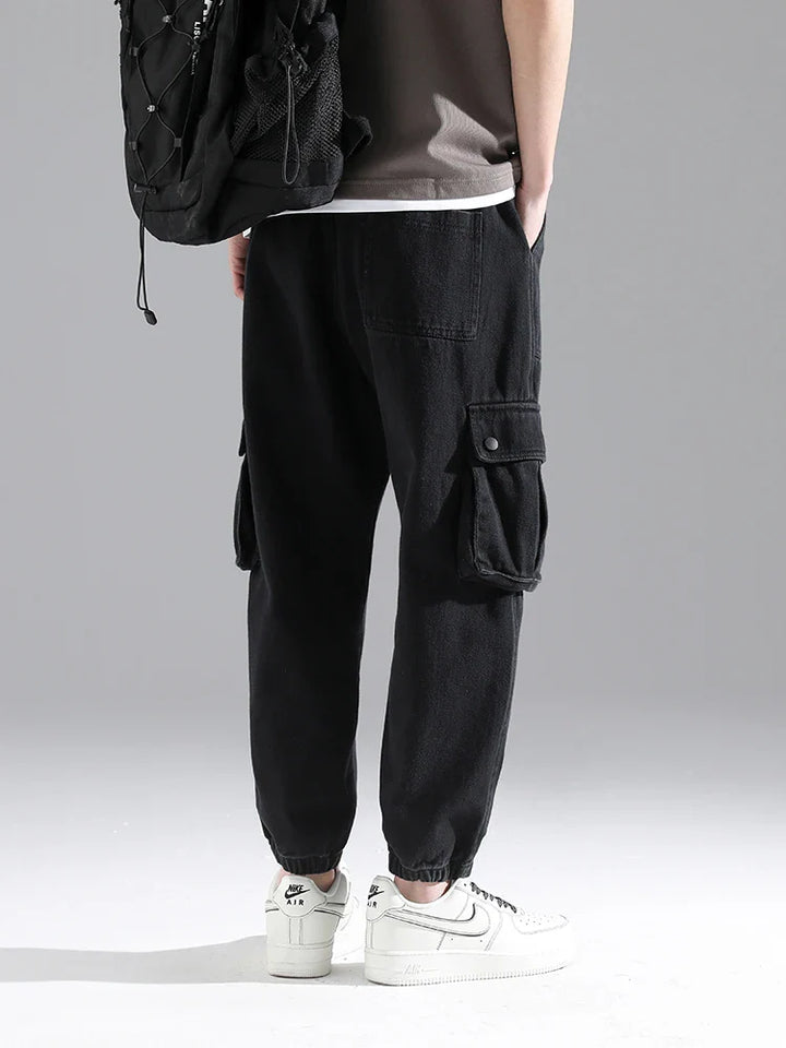 Lennox Cargo Joggers in black, featuring oversized snap pockets, elastic cuffs, and a relaxed tapered fit.