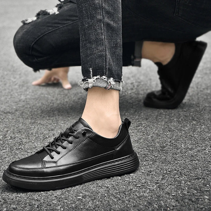 Aristo Oxford Shoes: sleek black genuine leather sneakers with low-top design and bold contrast laces on outdoor pavement.