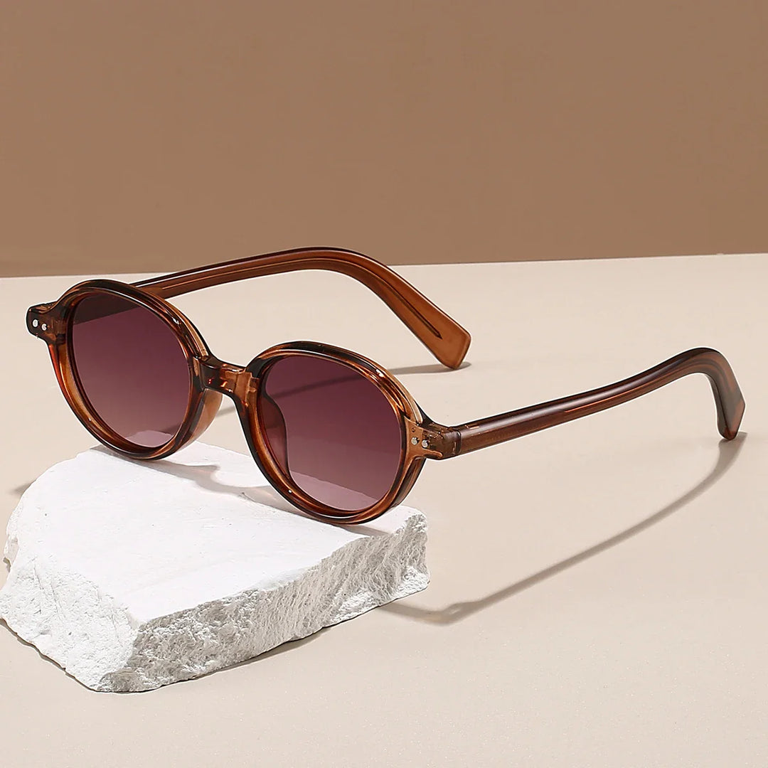 Sable round sunglasses with thick acetate frames and UV-blocking gradient lenses, resting on a stone surface.
