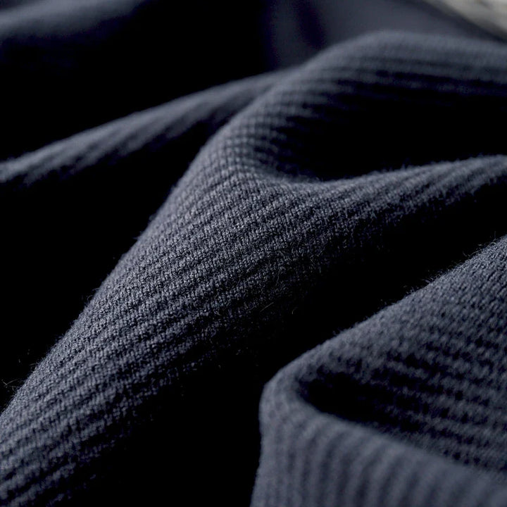 Close-up of soft, breathable navy merino wool fabric showcasing fine ribbed texture, ideal for Rowan Merino Cardigan.