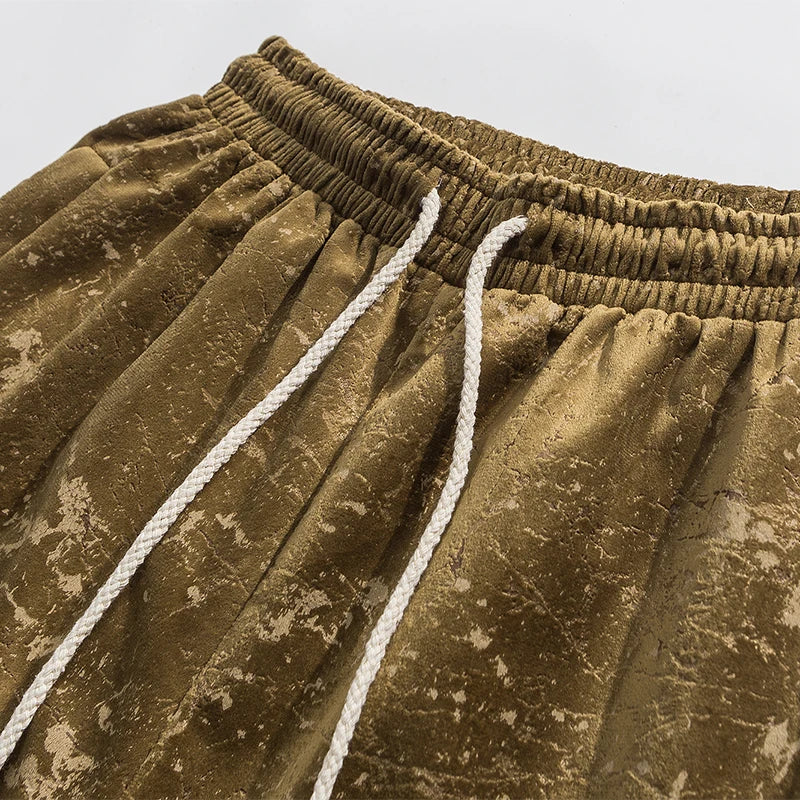 Close-up of crushed velvet joggers showcasing elastic waistband and drawstring, highlighting their luxurious texture.