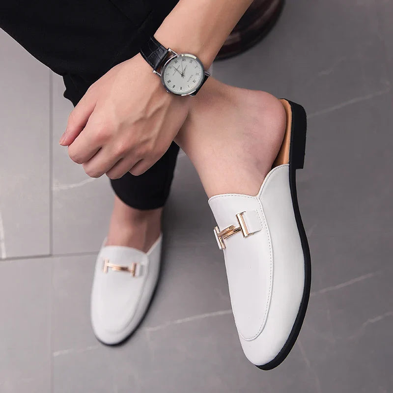 White Santino Backless Slide Loafers with gold bit detail, paired with a stylish watch, showcasing an elegant slip-on design.
