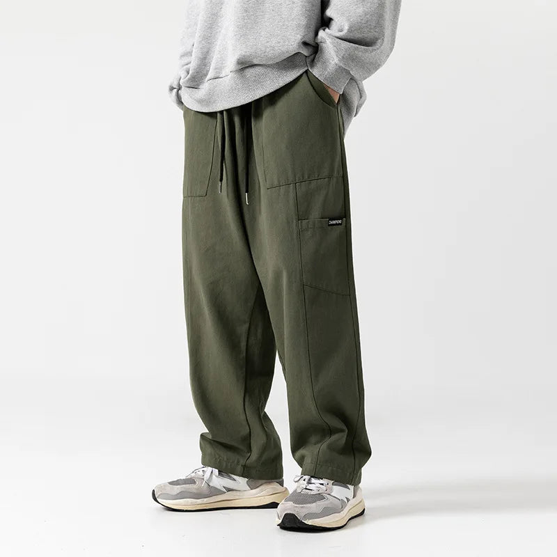 Huxley Men's 100% Cotton Cargo Pants in olive green, featuring oversized pockets and adjustable drawstring waist.