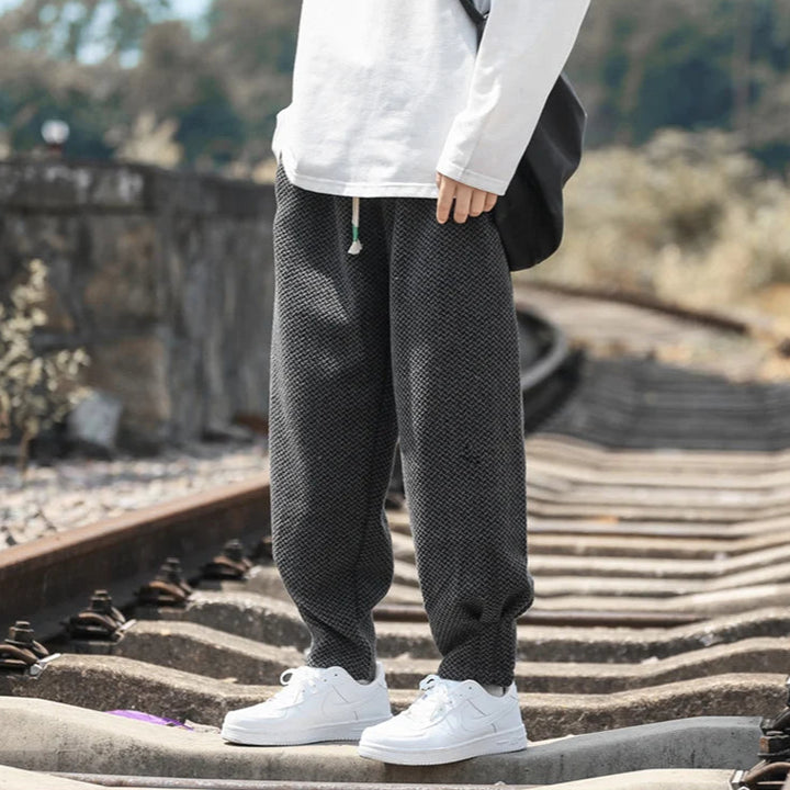 Oslo Textured Joggers in dark grey with relaxed fit, adjustable drawstring waist, and tapered cuffs on model.
