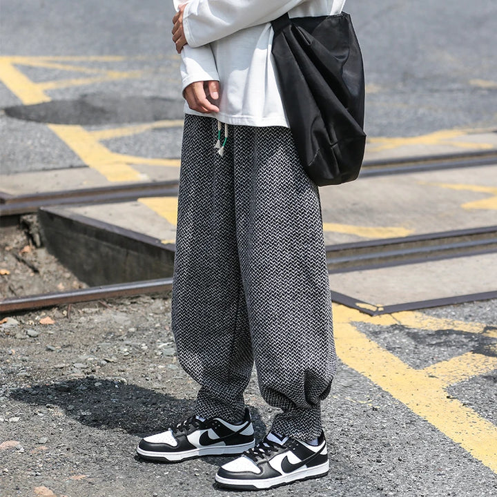Person wearing Oslo textured joggers with a relaxed fit, black sneakers, and a stylish bag on a city street.