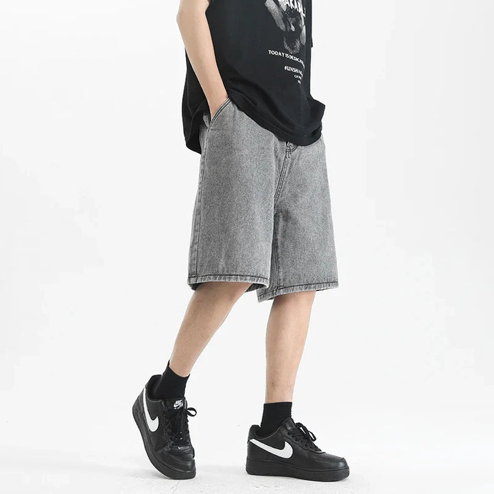 Lennox men's relaxed denim shorts in washed black, styled with an oversized tee and sneakers for a casual look.
