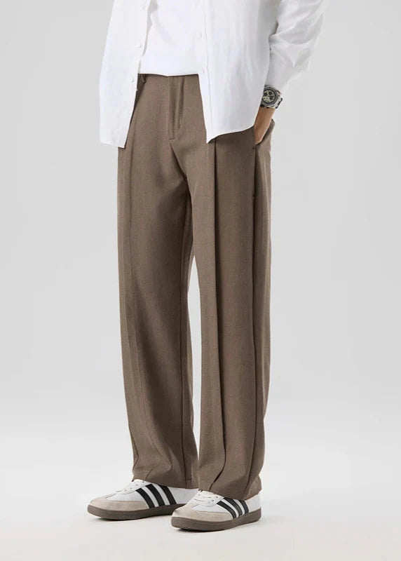 Calloway Pleated Trousers in light brown, relaxed straight-leg fit with elegant pleated front, paired with casual shoes.