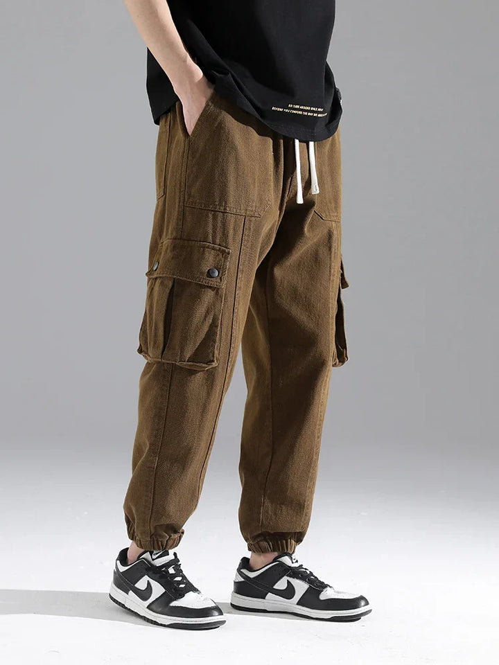 Lennox Cargo Joggers in brown, featuring oversized pockets, elastic ankle cuffs, and a relaxed tapered fit.