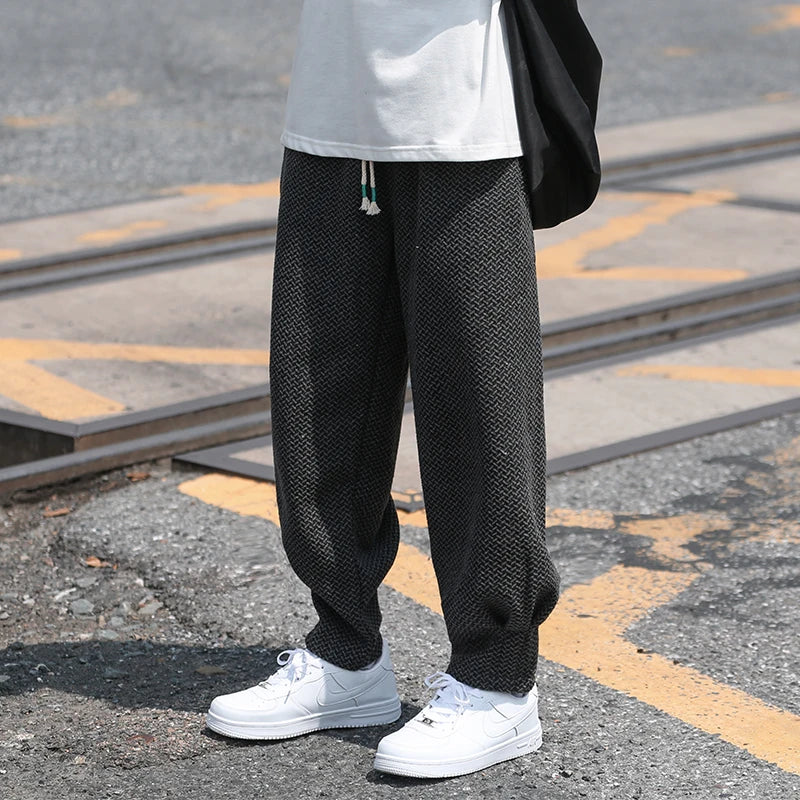 Oslo textured joggers in black with adjustable drawstring waist and tapered cuffs, paired with white sneakers on the street.