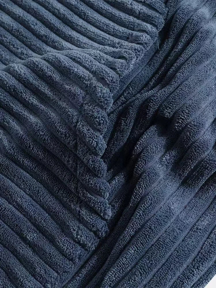 Close-up of soft, navy ribbed corduroy fabric showcasing texture and depth, perfect for cozy garments.