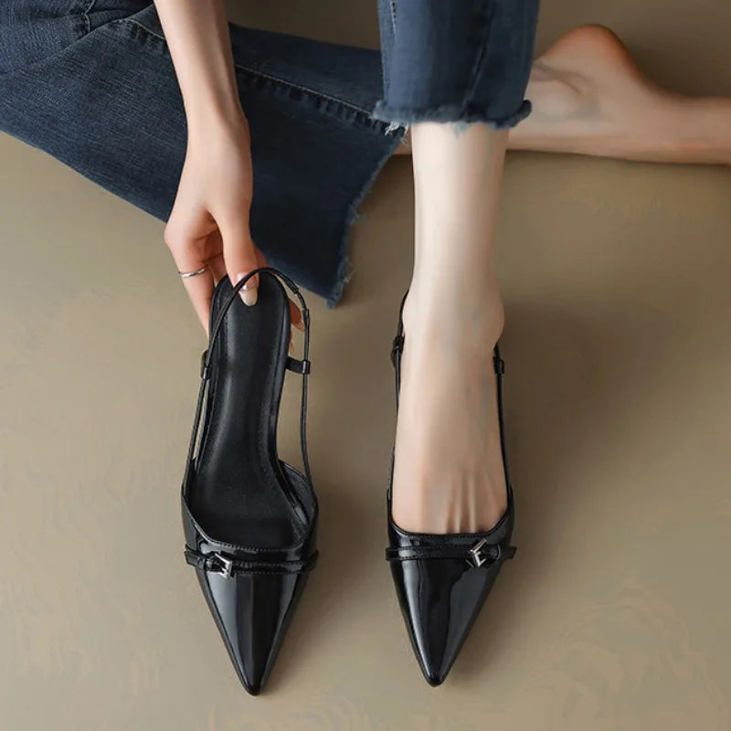 Pointed-toe slingback heels in glossy black, featuring a flared mid-heel and adjustable strap for comfort and style.