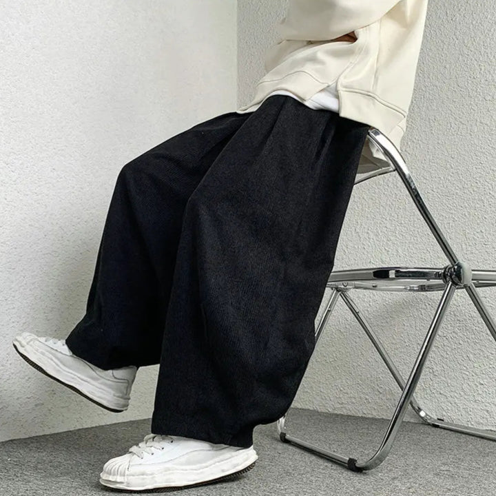 Model wearing Arlo corduroy pants with wide-leg fit, adjustable drawstring waist, and deep pockets.
