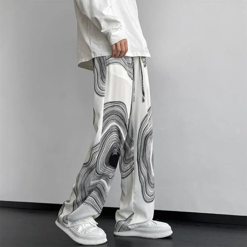 Flowing wide-leg Vortex Ripple Pants with a hypnotic abstract print and adjustable drawstring waist, showcasing effortless movement.