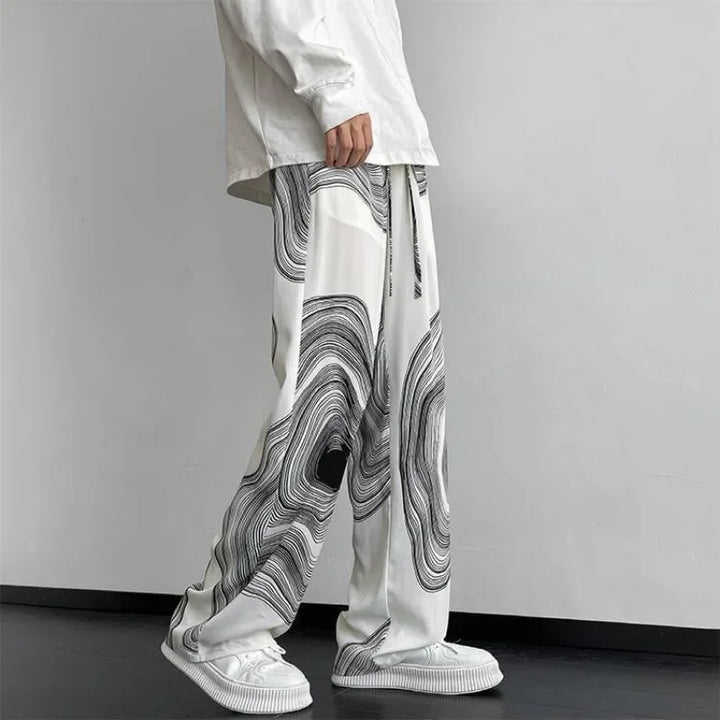 Flowing wide-leg Vortex Ripple Pants with a hypnotic abstract print and adjustable drawstring waist, showcasing effortless movement.