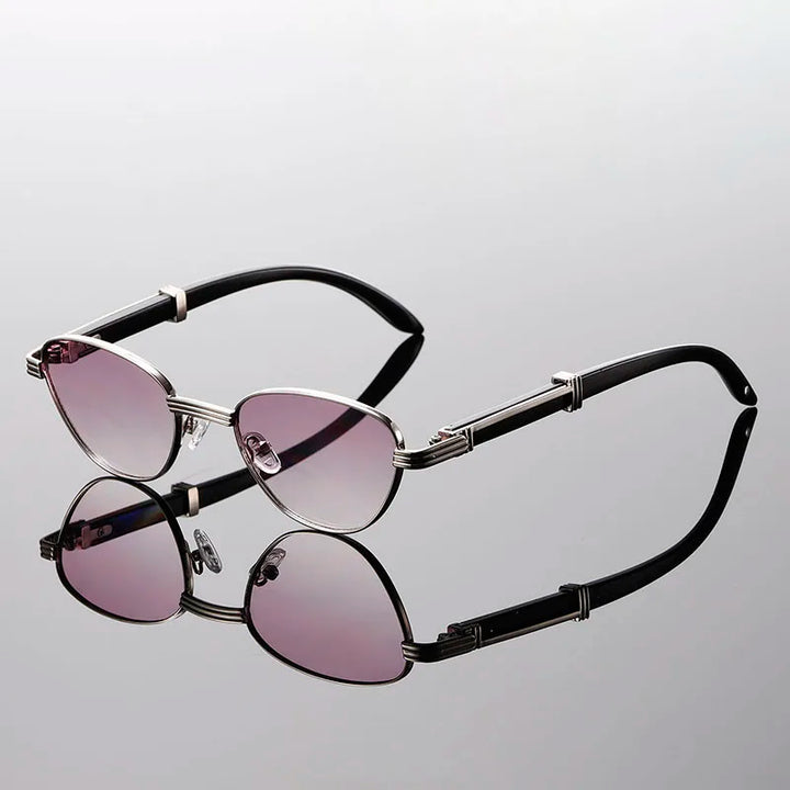 Orion Veil Sunglasses with gradient photochromic lenses and gold-tone frames on reflective surface.