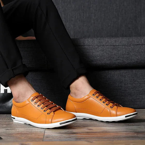 Paxton Low-Top Comfort Sneakers in orange with hidden lacing, showcasing sleek leather design and lightweight comfort.