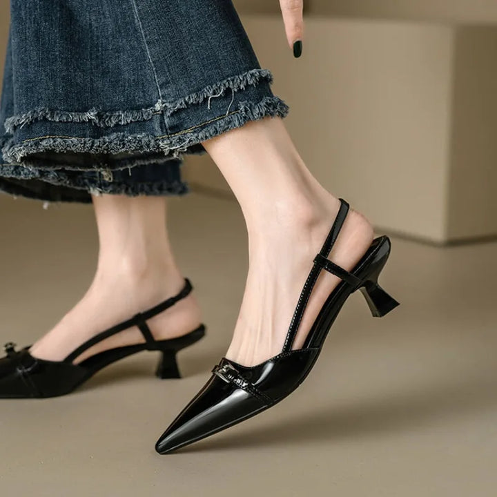Black pointy-toe slingback heels with flared mid-heel, showcased with stylish denim, perfect for chic outings.