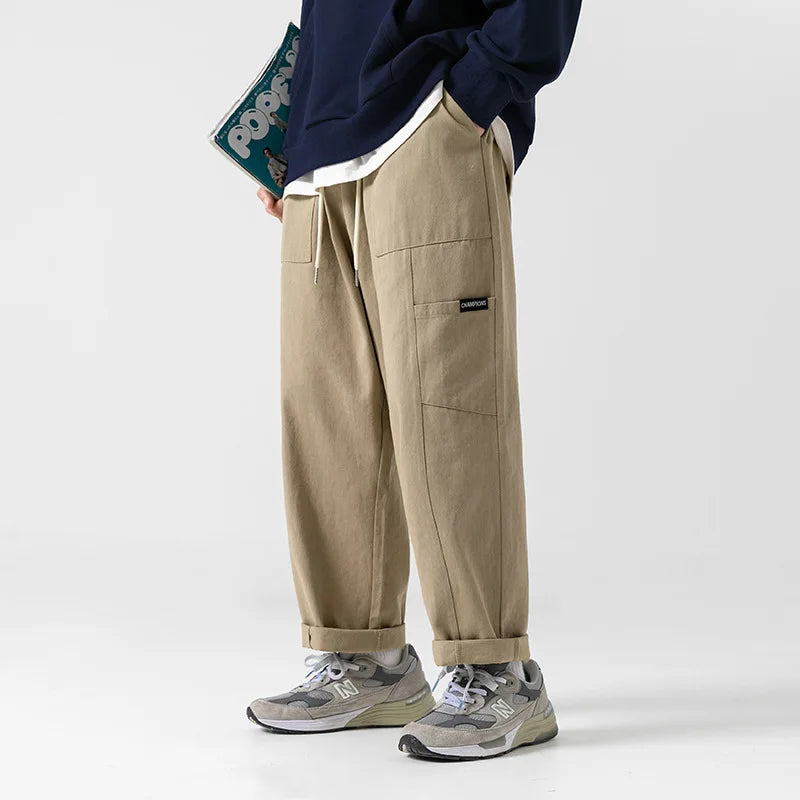 Huxley Men's 100% Cotton Cargo Pants in beige with oversized pockets and adjustable drawstring waist.